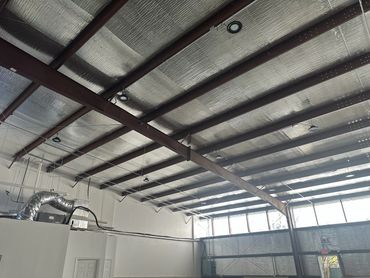 RB Warehouse's ShieldWrap in action covering the ceiling of a metal building.