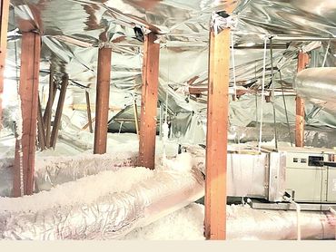 Photo of an attic with RB Warehouse radiant barrier covering both the roof deck and visible pipes.