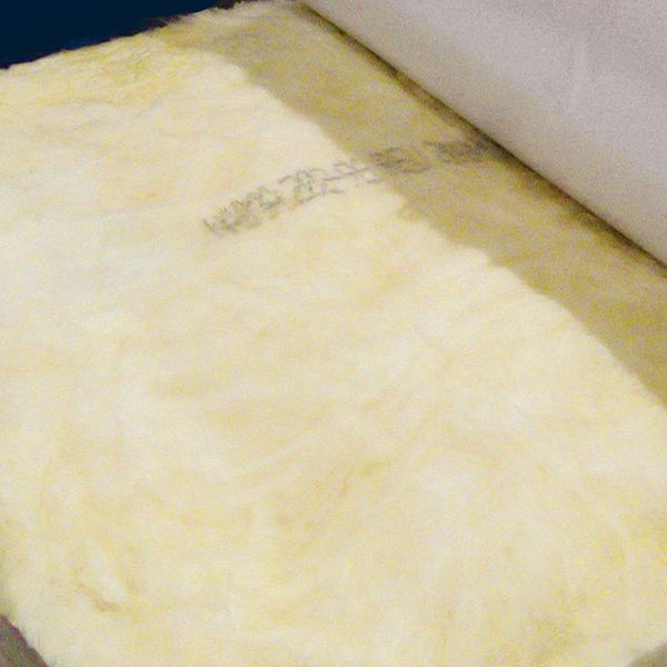 Close-up of faced fiberglass insulation during the manufacturing process.