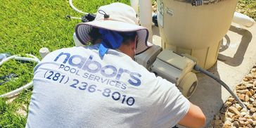 A close-up shot of a Nabors crew member diligently working on pool plumbing.