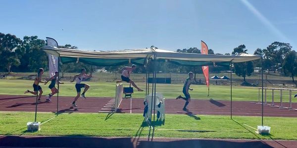 An MUAC athlete competing in the hurdles