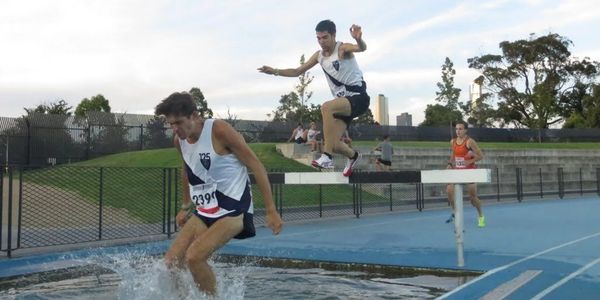 2 MUAC athletes in a steeple chase competition, 1 landing in the water and 1 mid jump