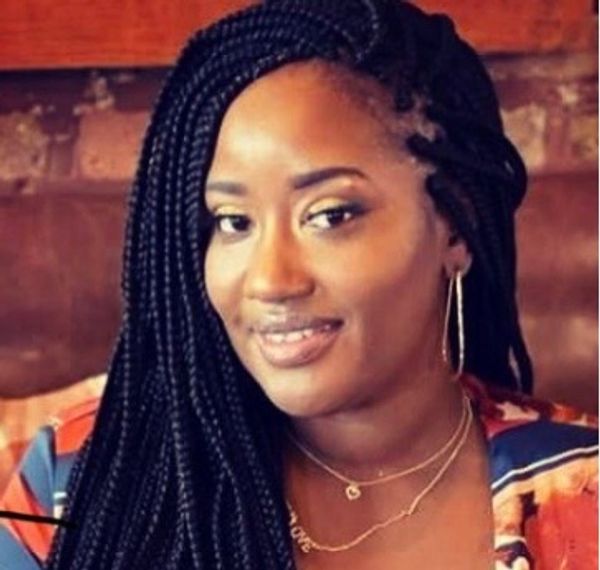 Woman with braided hair smiling warmly.
