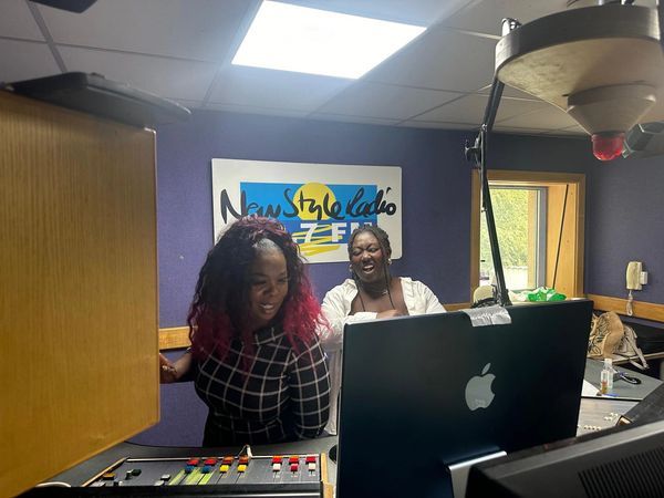 Co-hosts Annette B and Riri play some tunes from their laptop in the studio.