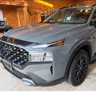 Front view of a gray Hyundai SUV parked inside a garage.