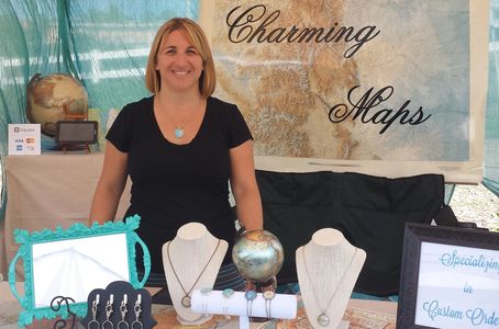 Charming Maps' very first booth setup at a local market.  Map jewelry on display and business sign made from a large map of Colorado.