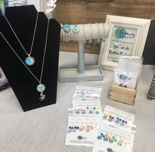 Jewelry and Gifts on display for sale.  Retail store display.  Wine charms, necklaces, and bracelets.
