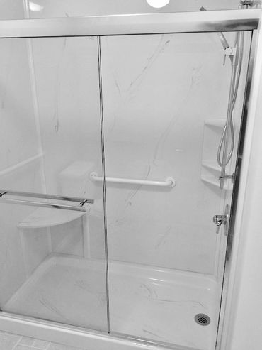 Bathroom renovation giving you a walk in shower with a cultured marble base and wall panels