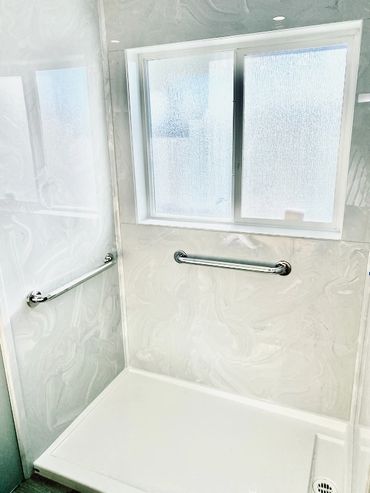 Bathroom renovation giving you a walk in shower with cultured marble wall panels