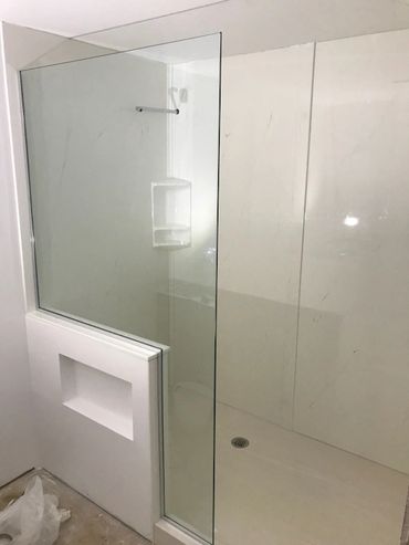Bathroom renovation with a walk in cultured marble shower base and wall panels
