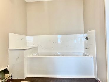 Bathroom renovation with a soaker tub and cultured marble tub panels
