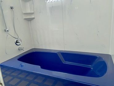 Beautiful solid colour soaker tub in cultured marble with cultured marble panels in a contrasting co