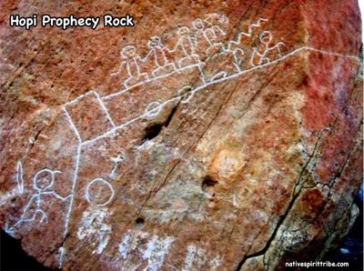 Ancient Hopi Prophecy Rock featuring symbolic white line drawings on a reddish stone surface.