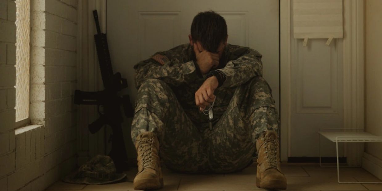 Exhausted veteran sitting alone | PTSD and emotional support | Safe Harbor Counseling