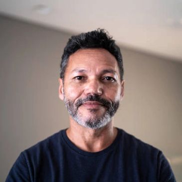Portrait of a middle-aged man with a beard and mustache wearing a dark shirt.
