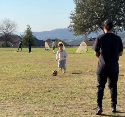 Coach Josh observing a youth player during a one-on-one soccer evaluation in Cedar Park.