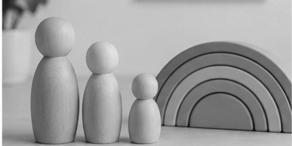 Wooden family figures with a wooden rainbow toy.