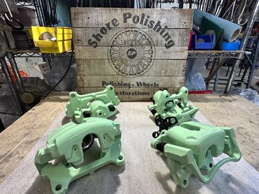 Freshly painted car brake calipers on a workbench in a shoe polishing workshop.