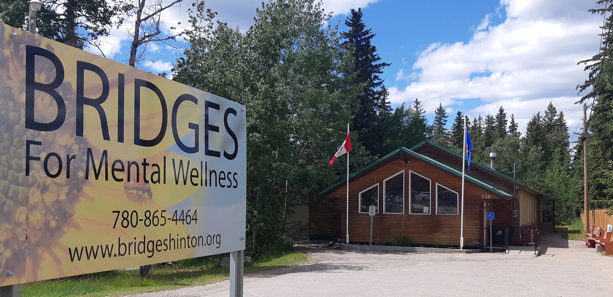 Bridges for Mental Wellness center with a large sign and flags outside.