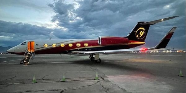 Private jet parked on runway at dusk.