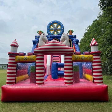 Colorful inflatable bounce house with horses and stripes outdoors on grass.