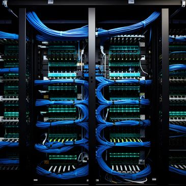 Neatly organized blue network cables in a server rack.