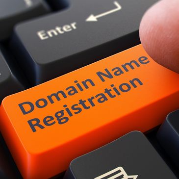 Finger pressing an orange keyboard key labeled 'Domain Name Registration'.