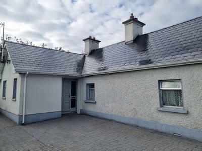 A house with two chimneys and black soot marks on the roof.