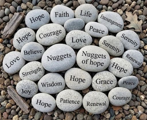 Smooth stones inscribed with uplifting words like Hope, Love, Courage, and Peace.