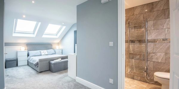 Modern bedroom with attached bathroom and skylights.