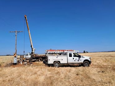 Sac River Electric work truck working outdoor repairing a electrical service on a Agriculture field.