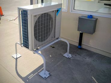 Outdoor Daikin air conditioning unit mounted on a sturdy metal stand.