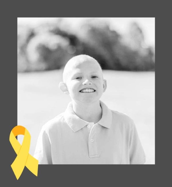 Smiling child with a yellow awareness ribbon.