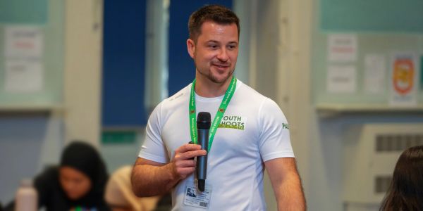 Man speaking with a microphone in a community setting.