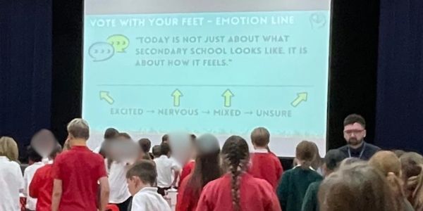 Children participating in an emotion line activity in a school hall.