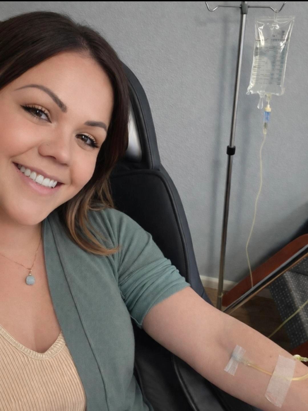 Smiling woman receiving IV treatment.