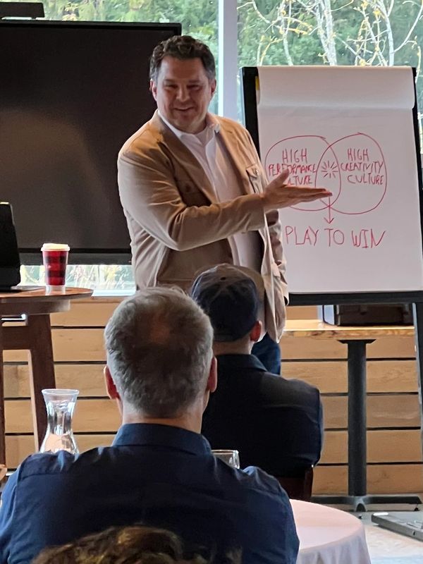 Man giving presentation on creativity and performance in a meeting room.
