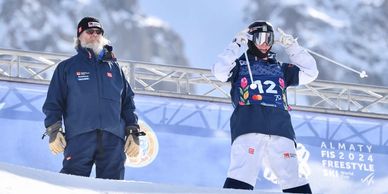 Two skiers on a snowy mountain slope at a competition.