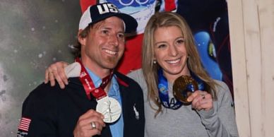 Two athletes proudly display their Olympic medals.