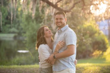 Couple embraces lovingly in a sunlit park.