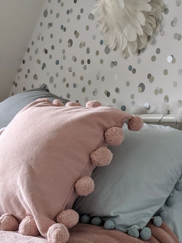 Girls bedroom design with wallpaper, cushion and wall decor styling