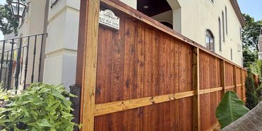 Cedar privacy fence and gate installation beside a Houston home