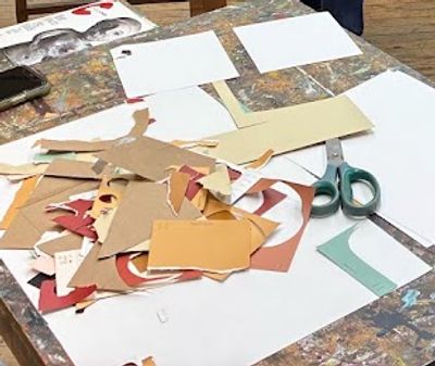 A messy table with paper scraps and scissors for crafting.