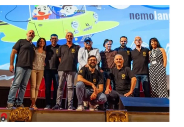 Group photo of people on stage with a colorful backdrop.