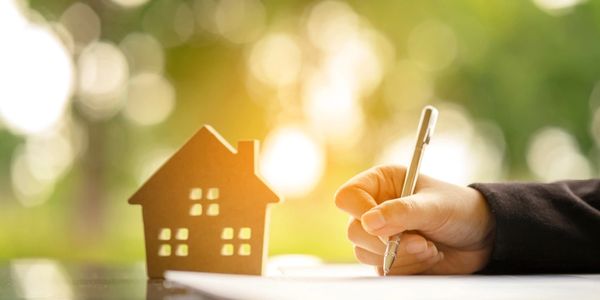 Young woman sign banking Loan Contract for buying a new land house from real estate agent