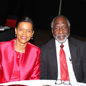 Smiling couple dressed in formal attire at an event.