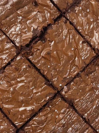 Close-up of freshly baked, cut chocolate brownies with a shiny crust.