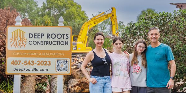 Family standing in front of their house being demolished, preparing for new construction custom home