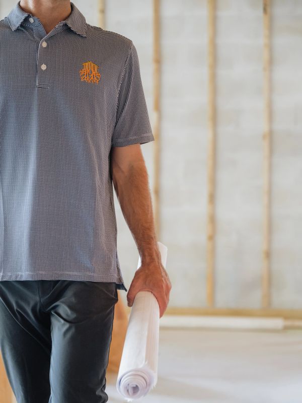 owner of deep roots walking a job with set of plans