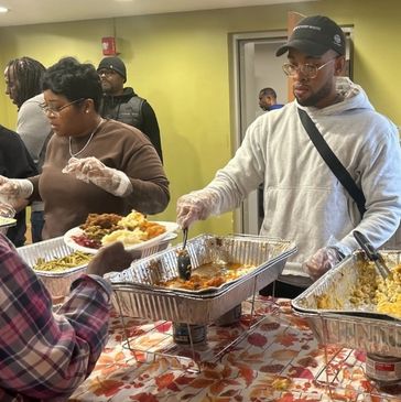 People serving food at a community event.